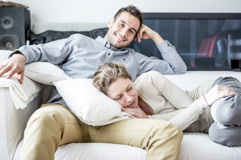 Couple relaxing on couch stock photo