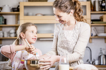 Mother and daughter baking in kitchen together - WESTF23059