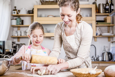 Mother and daughter baking in kitchen together - WESTF23061
