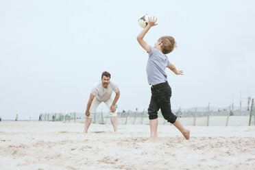 Vater und kleiner Sohn spielen mit Ball am Strand - MVCF00154