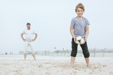Porträt eines lächelnden kleinen Jungen, der mit seinem Vater am Strand spielt - MVCF00156