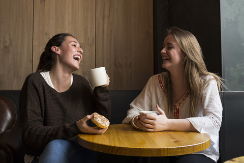 Zwei lachende Freunde in einem Kaffeehaus, lizenzfreies Stockfoto