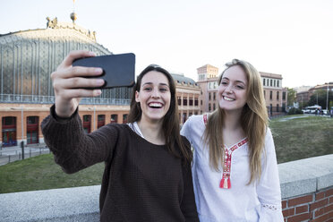 Spanien, Madrid, zwei Freunde machen Selfie mit Smartphone - ABZF01979
