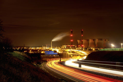 UK, England, West Yorkshire, Blick auf das Kraftwerk Ferrybridge bei Nacht mit der Autobahn im Vordergrund, lizenzfreies Stockfoto