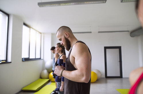 Gruppe von Sportlern beim Training mit Hanteln im Fitnessstudio - HAPF01607