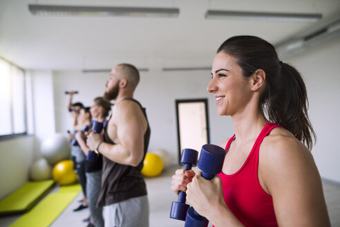 Gruppe von Sportlern beim Training mit Hanteln im Fitnessstudio - HAPF01608