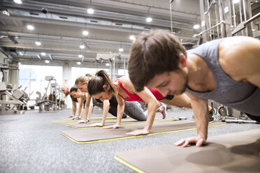 Young people exercising plank variations in a gym stock photo