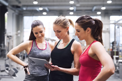 Drei Frauen mit Tablet nach dem Training im Fitnessstudio - HAPF01615