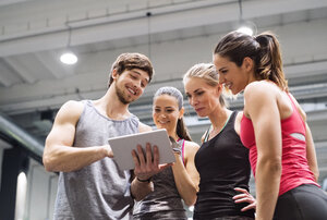 Gruppe glücklicher Sportler mit Tablet nach dem Training im Fitnessstudio - HAPF01617