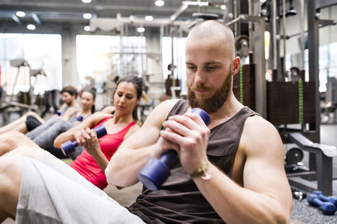 Gruppe von Sportlern beim Training mit Hanteln im Fitnessstudio - HAPF01620