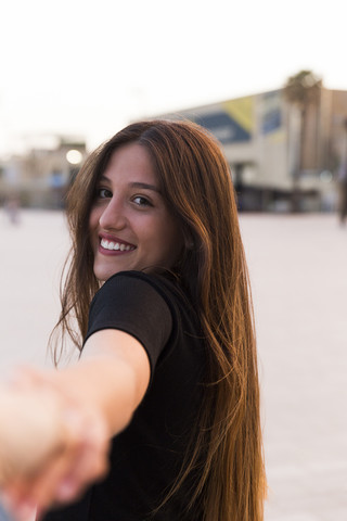 Porträt einer glücklichen jungen Frau, die die Hand hält, lizenzfreies Stockfoto