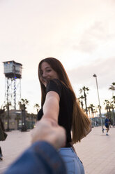 Spanien, Barcelona, glückliche junge Frau mit Hand - KKAF00748