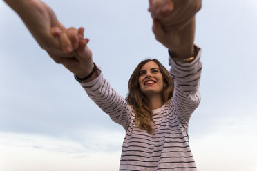 Two friends holding hands, view from below - KKAF00749