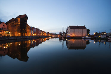 Poland, Gdansk, lighted row of houses with crane gate at Motlawa bank at dusk - ABOF00180