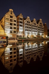 Poland, Gdansk, granaries on Granary Island with reflection on Old Motlawa river by night - ABOF00182