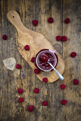 Spoon and jar of raspberry jam and raspberries on wood - LVF06065