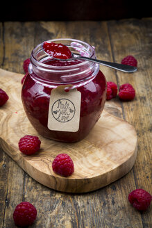 Löffel und Glas mit Himbeermarmelade und Himbeeren auf Holz - LVF06066