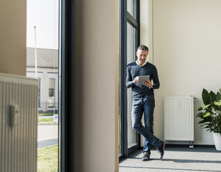 Geschäftsmann benutzt Tablet in seinem Büro - UUF10485