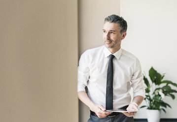 Portrait of businessman with tablet - UUF10509