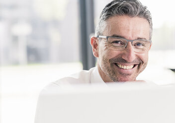 Portrait of happy businessman in the office - UUF10519