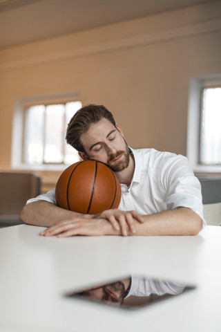 Porträt eines jungen Freiberuflers mit Basketball, der eine Pause macht, lizenzfreies Stockfoto
