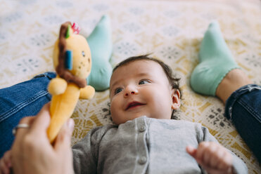 Mother playing with her baby daughter on couch - GEMF01601