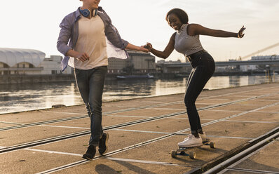 Junges Paar beim Skateboarden am Flussufer - UUF10540