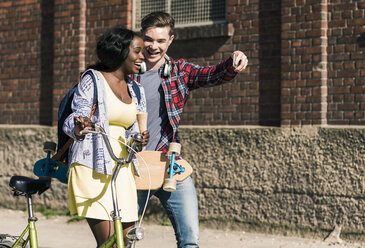 Young couple with bicycle and skateboard taking smartphone selfies - UUF10555