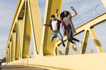 Glückliches Paar springt auf Brücke - UUF10589