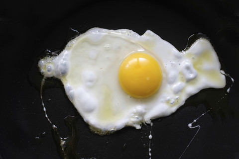 Fried egg on black background stock photo