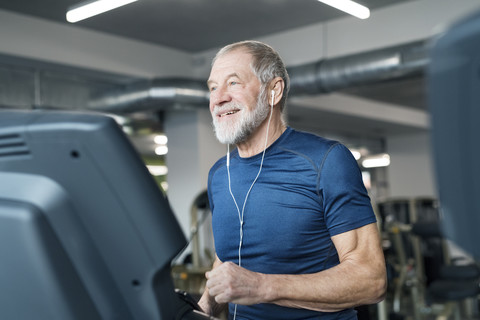 Fitter älterer Mann auf dem Laufband beim Training im Fitnessstudio, lizenzfreies Stockfoto