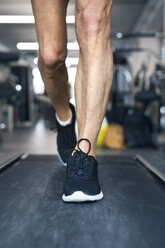 Beine eines Mannes auf Laufbändern im Fitnessstudio - HAPF01645