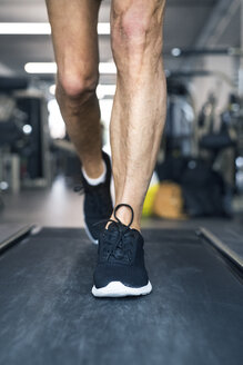 Legs of man on treadmills working out in gym - HAPF01645