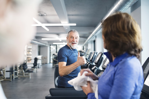 Group of fit seniors on treadmills working out in gym stock photo