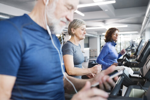 Group of fit seniors on treadmills working out in gym - HAPF01655