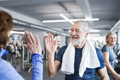 Happy senior man and woman high fiving after working out in gym - HAPF01665