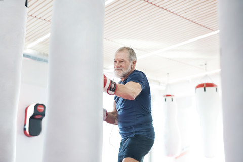 Fitter älterer Mann in Boxhandschuhen beim Kampf, lizenzfreies Stockfoto