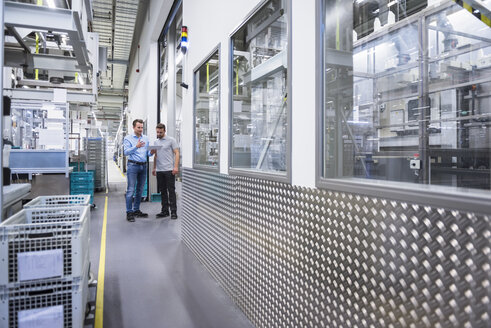 Two men with tablet talking in factory shop floor - DIGF02339