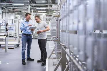 Two men with tablet talking in factory shop floor - DIGF02341