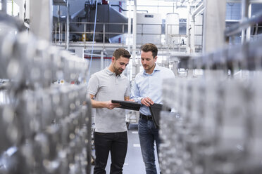 Two men with tablet talking in factory shop floor - DIGF02352