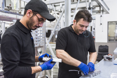 Zwei Männer arbeiten in einer Fabrikhalle - DIGF02358