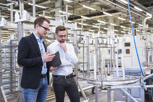 Two men talking in factory shop floor - DIGF02370