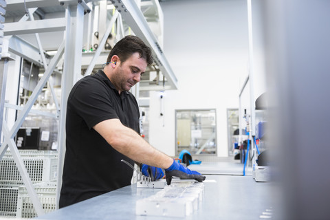 Mann arbeitet in einer Fabrikhalle, lizenzfreies Stockfoto