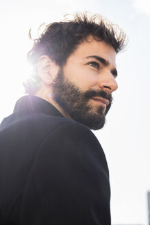 Portrait of young man with full beard at backlight - ABZF01988