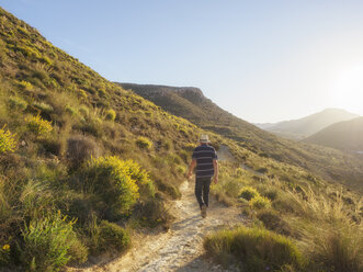 Spain, Andalusia, Cabo de Gata, back view of man hiking - LAF01835