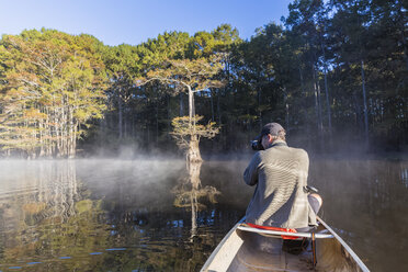 USA, Texas, Louisiana, Caddo Lake, Sumpfzypressenwald, Tourist mit Kamera im Kajak - FOF09248