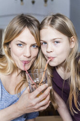 Mother and daughter sharing an orange juice - TCF05401