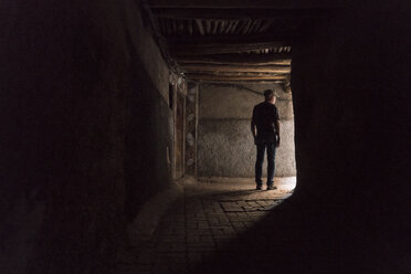 Morocco, Marrakesh, tourist standing in a passageway - KKAF00778