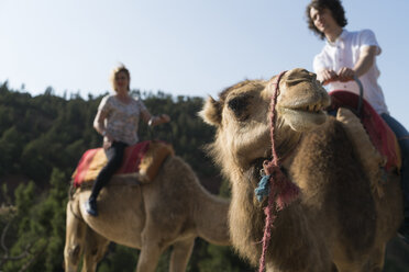 Marokko, Mann und Frau beim Kamelreiten - KKAF00809
