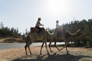 Marokko, Mann und Frau beim Kamelreiten - KKAF00810